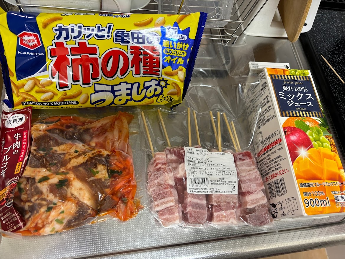 いなげや花小金井駅前店で買ってきた亀田製菓 柿の種 うましお 6袋 追いがけ 旨みブレンド オイル、牛肉のプルコギ（冷凍）、豚バラ串30g（8本）とかんずり（濃縮香辛寒作里）、果汁100％ミックスジュース900ml