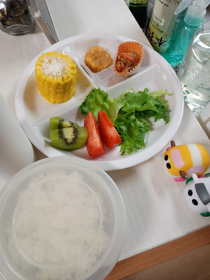 トウモロコシ、チキンナゲット、きんぴら、キウイフルーツ、トマトとレタスのサラダ