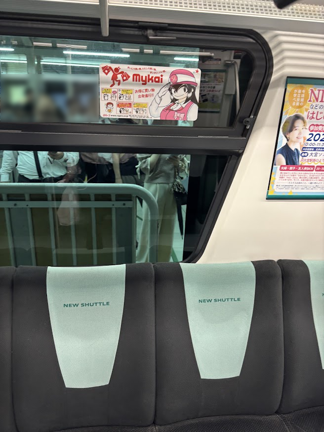 ニューシャトル内の埼玉ローカルのディスカウントスーパー「ロヂャース」のマスコット「原嶋ろぢゃミ」広告