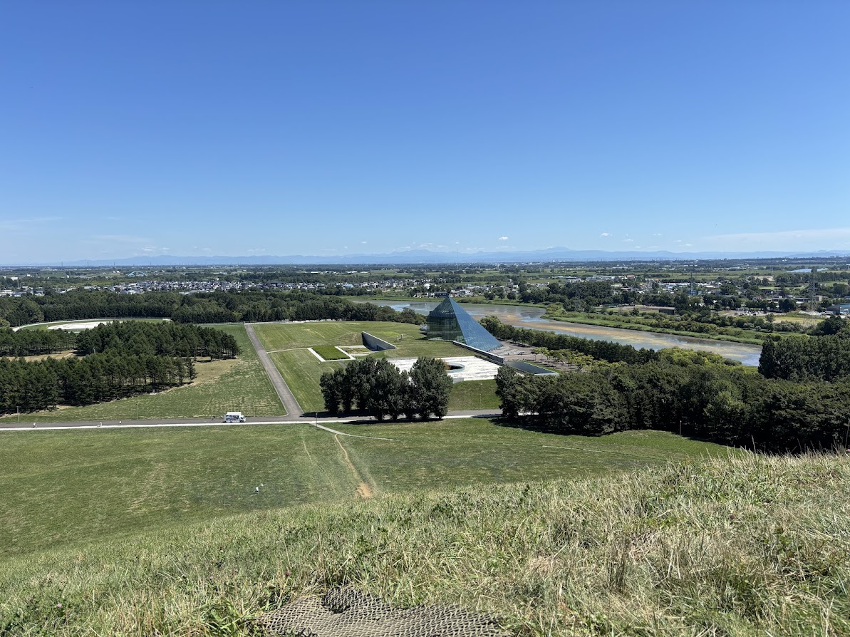 モエレ沼公園のモエレ山、山頂からネルフ本部（ガラスのピラミッド "HIDAMARI"GLASS PYRAMID "HIDAMARI"）