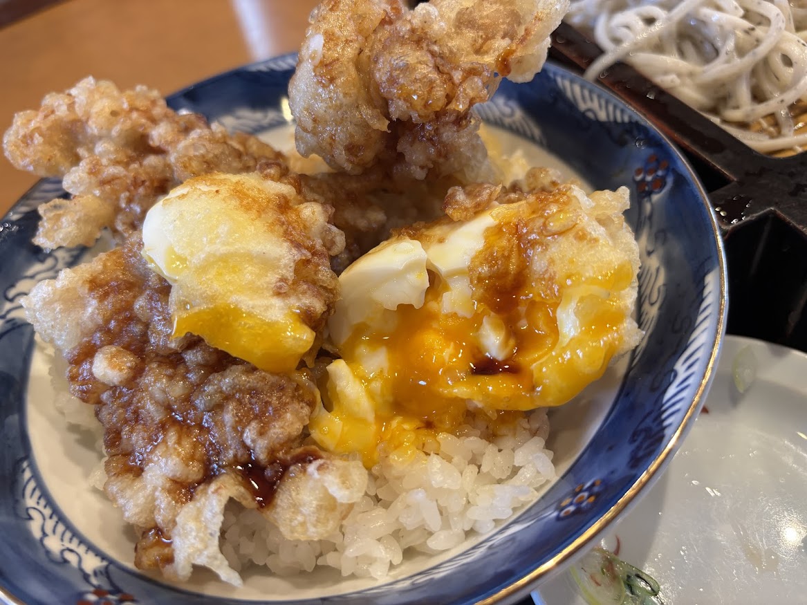 ごまそば遊鶴北38条店でもりそばと鶏親子天丼セットで鶏親子天丼の卵天を割り、出て来たトロっとした黄身に丼たれをかけていただく