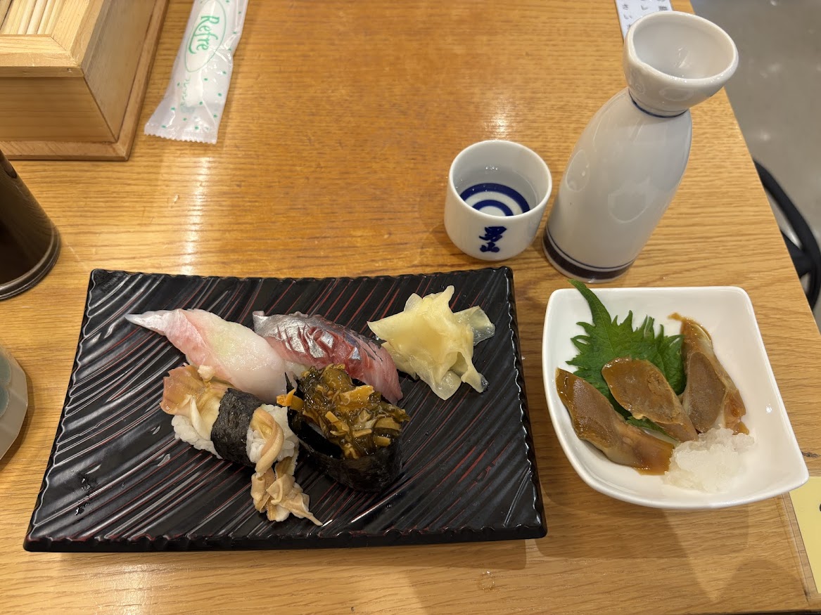 「北の味覚 すず花 ゲート店」で八角、生にしん、ホッキヒモ軍艦、松前漬け軍艦、自家製イカゴロルイベと日本酒 男山 秘造り 熱燗（一合）