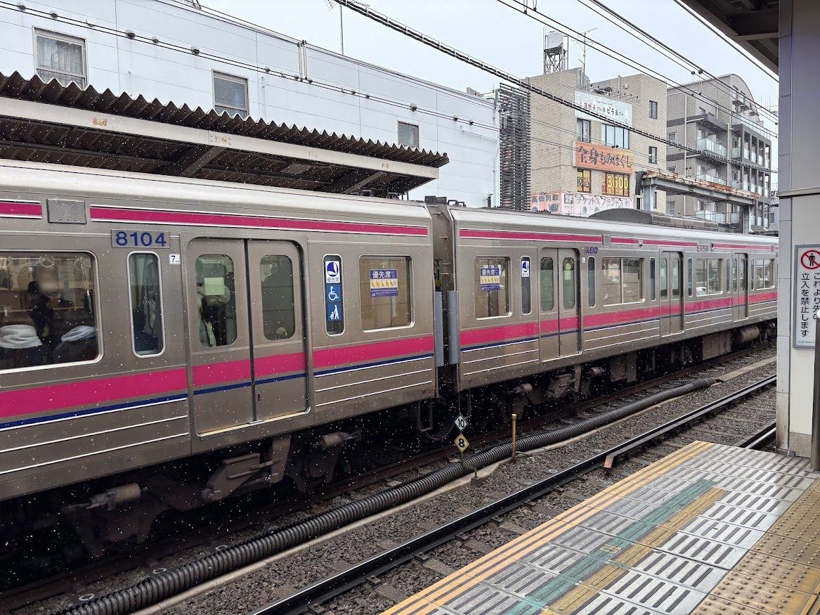 雪が降る千歳烏山駅ホームと京王線車両