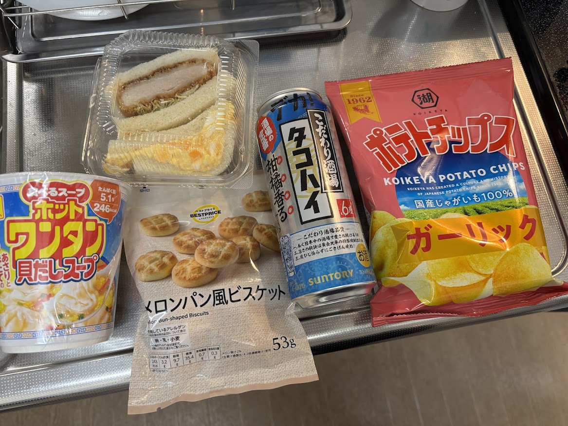 食べるスープ ホットワンタン 貝だしスープ（あさりとほたての旨み）、ロースカツ＆たまごサンド（いなげや惣菜）、トップバリュ メロンパン風ビスケット、タコハイ、こいけやポテトチップス ガーリック