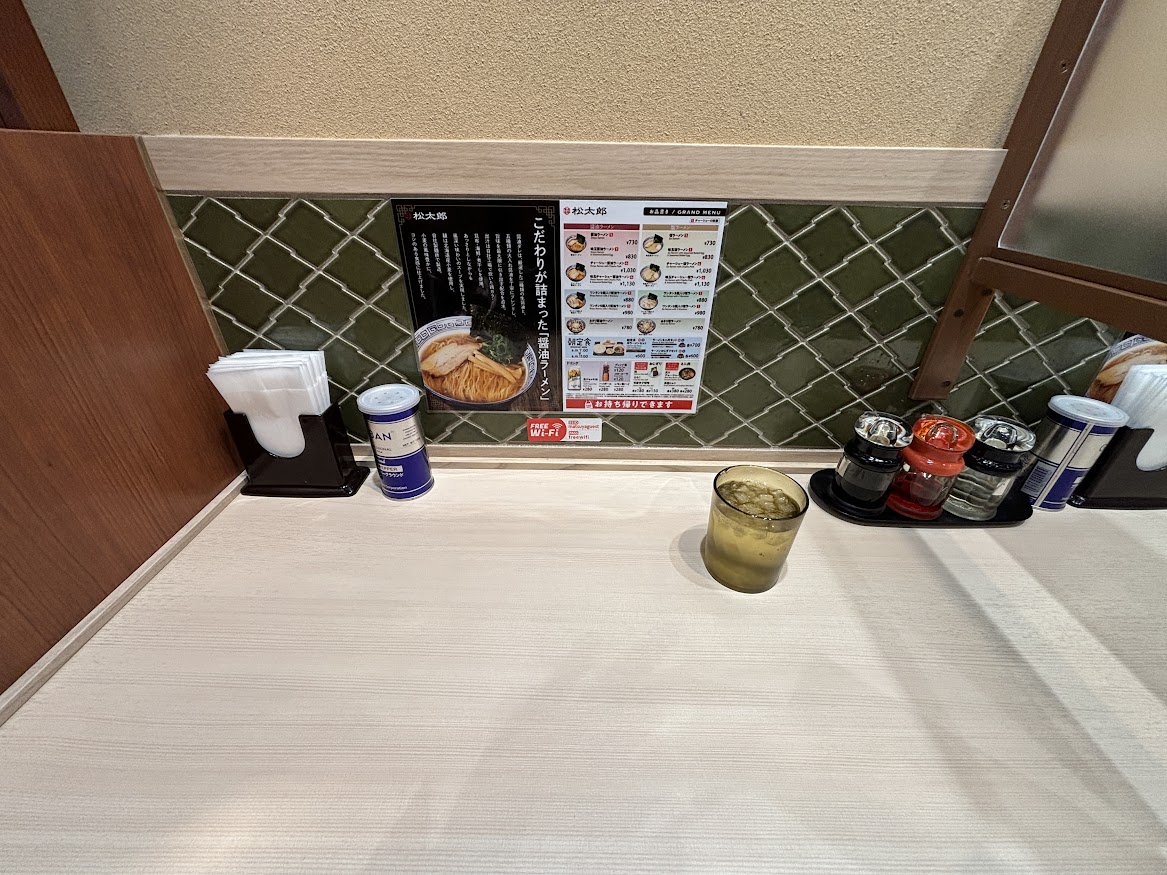松太郎 新宿小滝橋通り店 卓上調味料とメニューと醤油ラーメンの説明