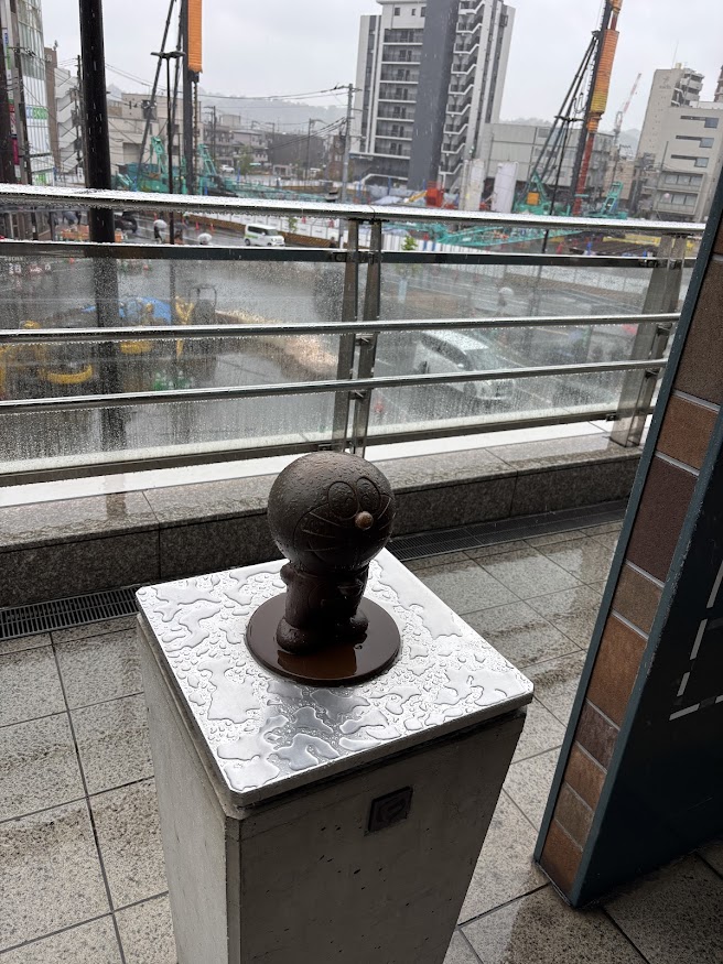 登戸駅の雨に濡れるドラえもん像